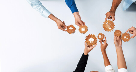 This image showcases a diverse group of hands connecting gears that symbolize teamwork and innovation in technology, highlighting collaboration and strategic planning in a professional setting. Amity