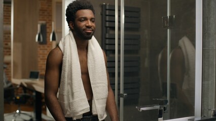 African American ethnic bare man smiling in mirror reflection in bathroom bearded male guy shaving...