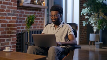 African American man businessman business employer typing laptop in night office overtime online...