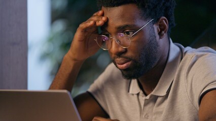 Stressed businessman African American business man in office deadline difficult job problem laptop...