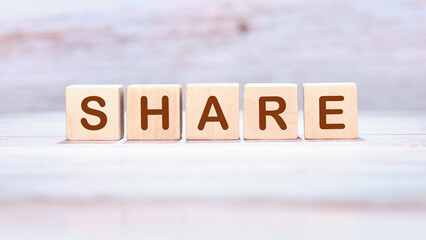 The concept word SHARE is made of wooden cubes on a light background. Technology, website concept