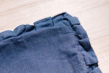 Blue blanket with a stitched border, folded neatly on a light surface.