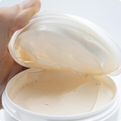 Opened container of adhesive glue with creamy texture, used for cork installation.