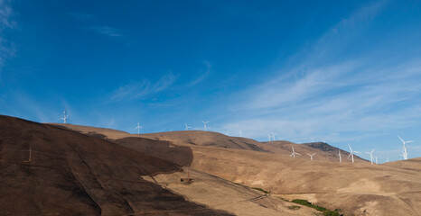 Wind Turbines among the hills against a blue sky, landscape