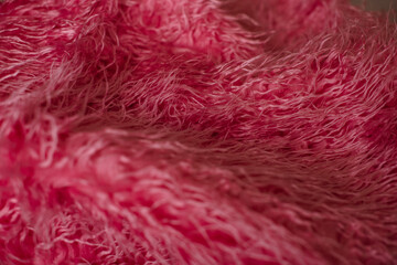 Fluffy pink fabric texture in close-up, showcasing soft and cozy material.