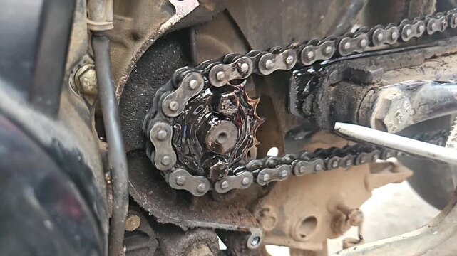 Slow motion closeup of Motorcycle chain in a workshop.