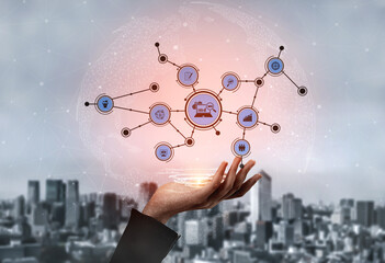 An innovative hand holds a digital network of connection icons above an expansive urban city,...