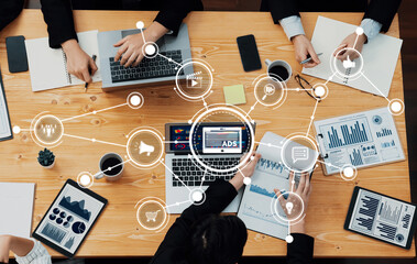 Top view of a business meeting showcasing teamwork and data analysis with laptops, charts, and...