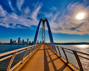 Modern Arch Bridge Over Water with City Skyline Keywords: bridge, modern, architecture, water