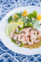 Shrimp sandwich on a wrap bread with eggs, lemon, and herbs.