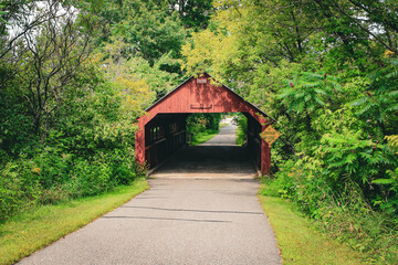 A charming red covered bridge located on the Cedar Creek Bike & Pedestrian Trail in Rothschild, Wisconsin.