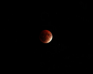 A stunning view of a lunar eclipse, showcasing the blood moon against a dark, starry sky