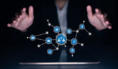 A businessperson uses hand gestures over a digital screen displaying abstract icons, representing modern connectivity and innovative technology in communication. Tessel