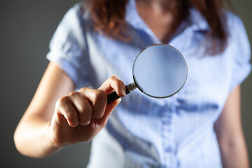 woman looking through magnifying glass