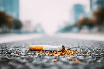 Cigarette discarded on an empty city street in the early morning