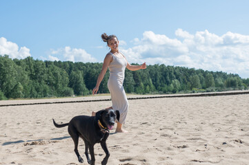 Caucasian woman walking on the beach with her dog. 