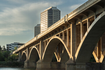 Bridge spans a river with a city skyline in the background