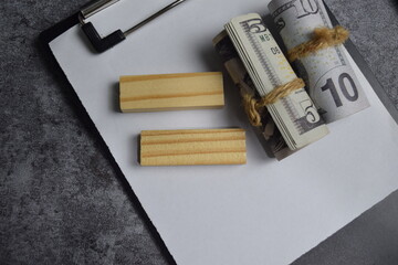 Concept of dollar above on clipboard isolated on Wooden Table.