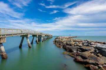 Obraz premium Jetty Park Pier at Port Canaveral Florida. Long exposure for motion blue in sky and water