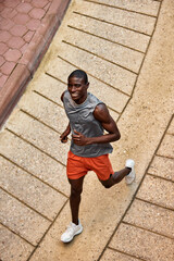 Man running outdoors on a sunny day in a vibrant urban setting