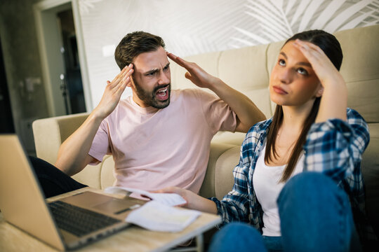 Stressed couple arguing over unpaid bills at home