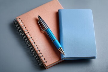 Stylish Notebooks and Pen on Grey Surface