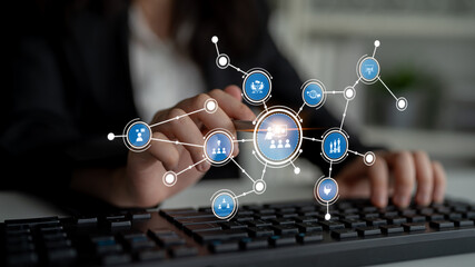 A business professional engages with a digital interface featuring various network icons. This...