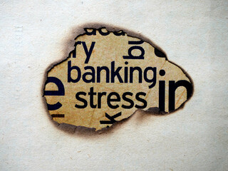 A close up image of the word banking and stress printed on a burnt paper