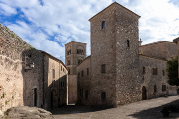 Trujillo medieval stone buildings and church tower rising under blue sky