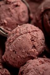 Creamy raspberry ice cream scoops in close-up, rich texture and vibrant pink color