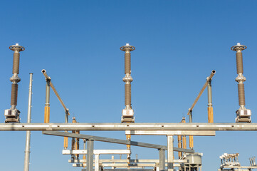Electrical infrastructure components at a utility-scale energy facility under construction, featuring high-voltage connectors and metal framework for power transmission systems