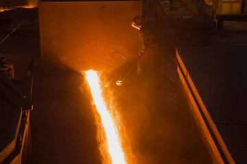 stream of molten steel flowing from a blast furnace.