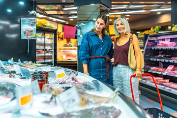 Women shopping for fresh seafood in supermarket