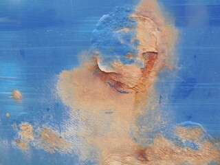 There are very noticeable traces of rust on the surface of an old metal car painted blue.