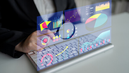 A business professional engages with digital performance metrics on a sleek keyboard, showcasing advanced data visualization through interactive graphs and charts. Impute