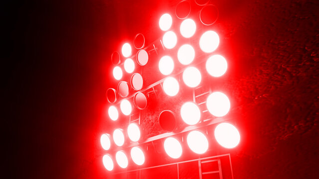 Powerful stadium lights casting a vibrant red glow illuminate the night sky, creating a dramatic and energetic atmosphere perfect for sporting events and performances - Powered by Adobe