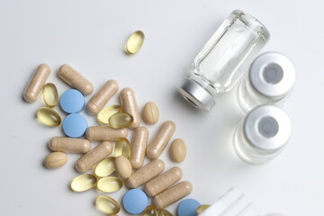 Vitamins pills and injectable in a white background