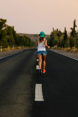 Fototapeta premium Young sporty woman running on asphalt road at sunset