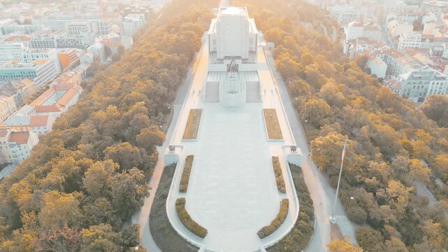 Experience the breathtaking sunrise over Vitkov Hill in Prague, revealing the impressive national monument dedicated to Jan Zizka amidst lush greenery and calm surroundings.