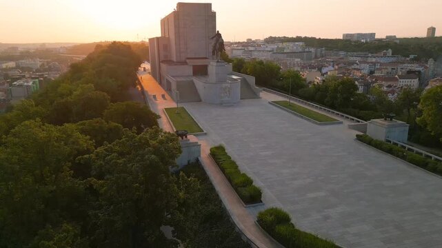 Witness the beauty of Vitkov Hill in Prague during sunrise. Admire the impressive national monument with statue of Jan Zizka surrounded by lush greenery and the serene morning atmosphere.