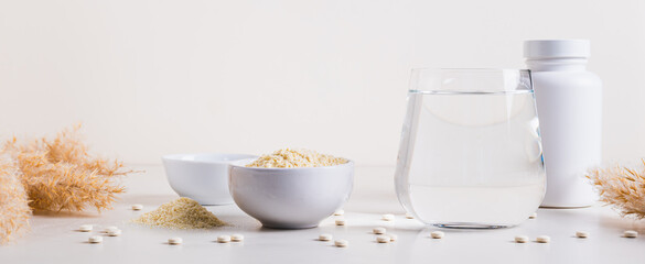 Peptide powder in a bowl and a glass of water on the table web banner