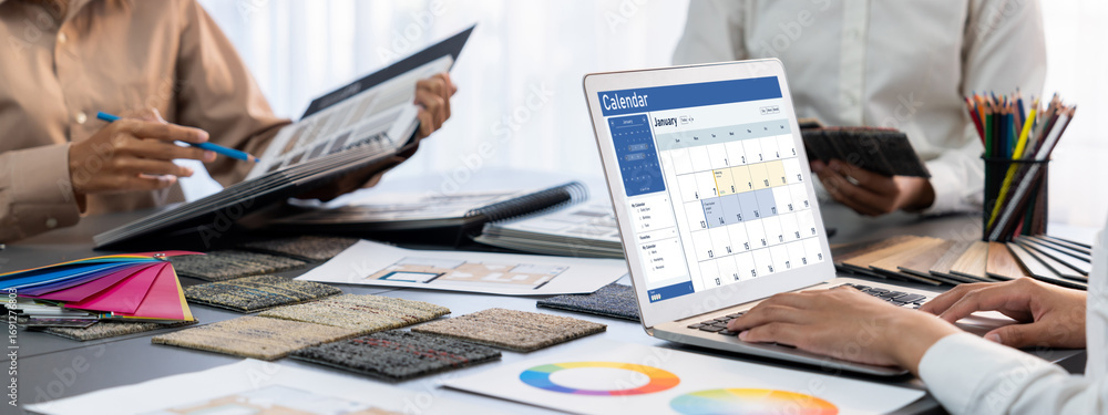 Poster group of interior architect designer team at table choosing color samples with architecture software