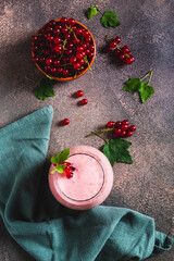 Red currant soy milk smoothie in glass on table top and vertical view