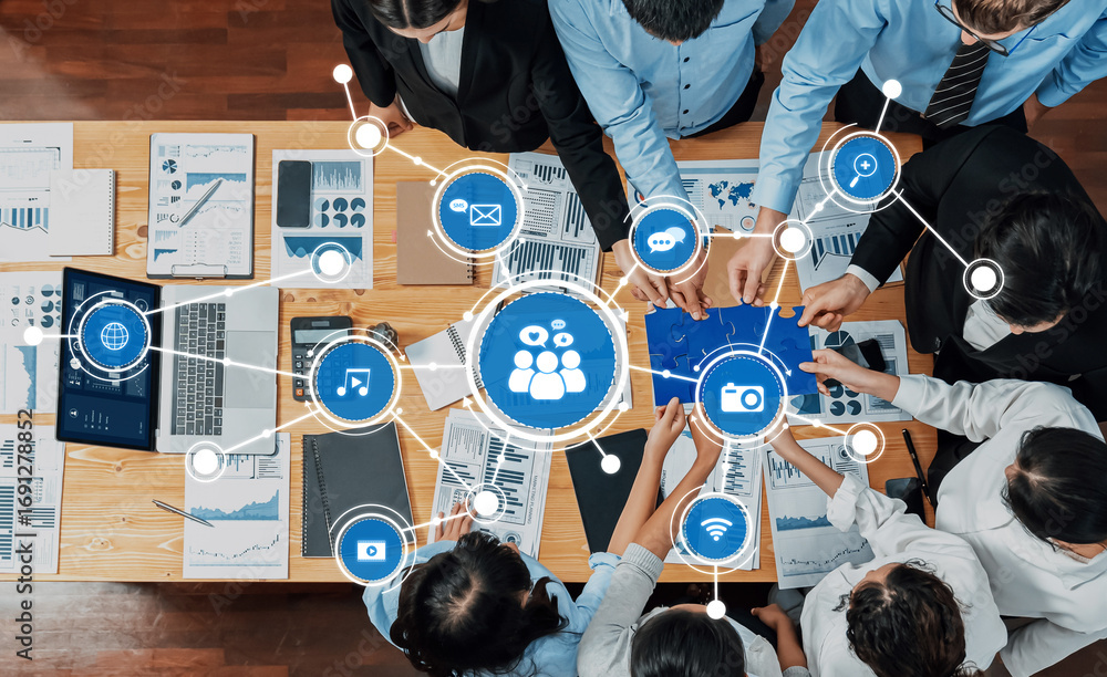 Poster A diverse group of professionals collaborates in a business meeting. Digital media graphs and infographics are displayed on the table, highlighting data analysis and teamwork. Amity