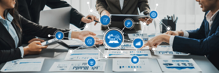 A diverse team of business professionals engages in collaborative discussions over data charts and...