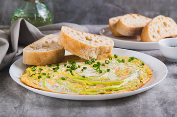Fried eggs with zucchini noodles and ciabatta on a plate on the table