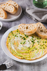 Protein omelette on zucchini noodles on a plate on the table vertical view