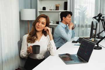 Profile smiling beautiful Asian businesswoman looking camera while holding cup to pose at modern...