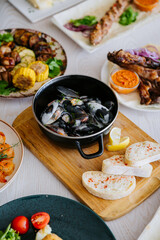 Black mussels in creamy sauce with herbs, served with rustic bread and lemon wedges