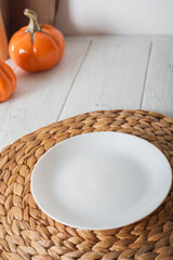 Empty White Plate on Autumn Table Setting with Pumpkins